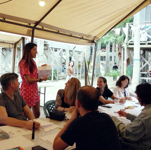 Molly Maine running a creative workshop at Synapse Festival in Japan, teaching illustration and collage techniques to an engaged group.