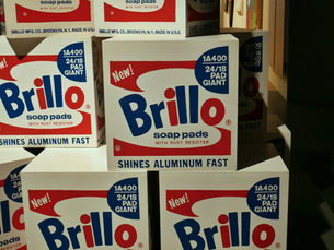 The accompanying photo of stacked Brillo boxes captures a portion of a 2002 Andy Warhol exhibition at the Museu Coleção Berardo in Lisbon, Portugal. Warhol, who studied advertising, was deeply influenced by its communicative power and the technical artistry of graphic design.
