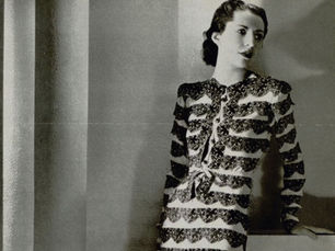 A black and white 1937 photo of a model wearing a full-length Balenciaga gown.