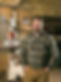 a man smiling standing in his custom furniture workshop,