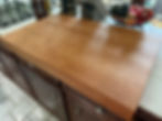 Angled view of a solid hardwood pasta board highlighting its thickness and smooth handcrafted edge.