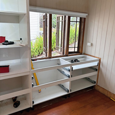Flat-pack kitchen cabinets being installed in Brisbane timber floor kitchen