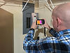 inspector using inrared camera on electrical panel