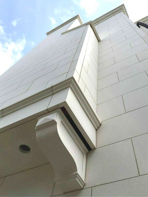 Close-up of a precision-cut mitered corner cornice profile fabricated from premium architectural limestone.