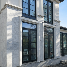 Full-view of a luxury multi-story residence featuring extensive Harbor Grey Limestone cladding and integrated architectural glazing.