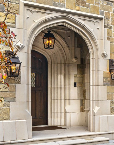 Deep-set Lueders Limestone arched doorway featuring custom stone headers and sharp profile geometry.