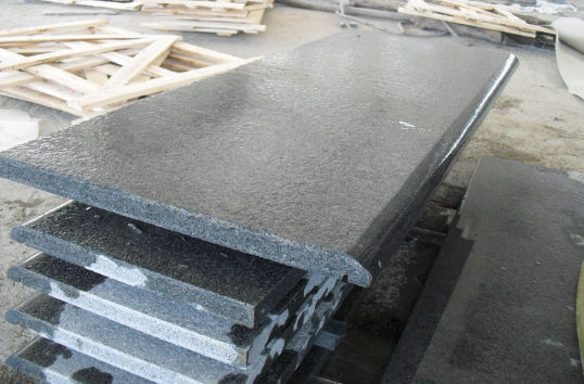 Oversized Obsidian Basalt paving slabs in a honed finish, showcasing the material's uniform fine-grained texture and durability for high-end commercial hardscaping.