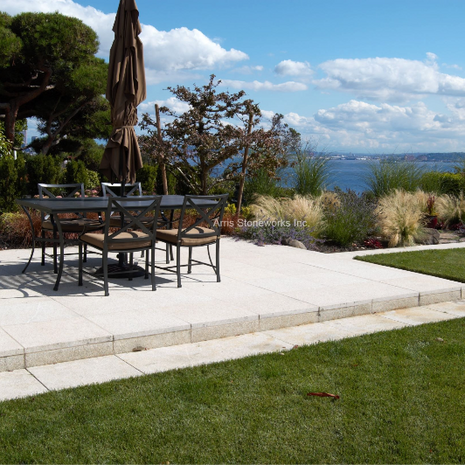 Large-format Tuscan Granite pavers with a honed finish create a clean outdoor dining area at the Magnolia Residence.
