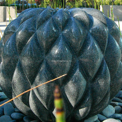 Close-up of a Sea Green Granite sculpture during the fabrication process, showing the intricate, interlocking geometric "pillow" pattern.