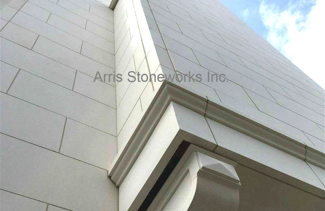Detail shot of custom-cut Eggshell White Limestone roofline coping and architectural trim, showcasing Arris Stoneworks' precision fabrication.
