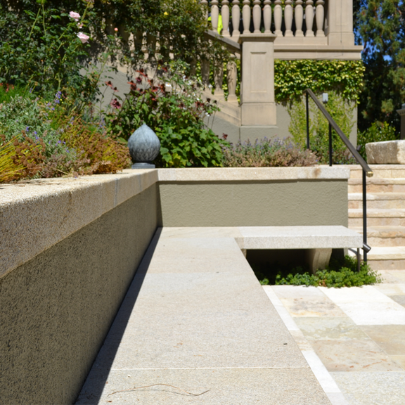 A contemporary garden pathway composed of small-format Gold Beige Granite cobble pavers, showcasing clean linear joints and a durable, highly textured surface finish.