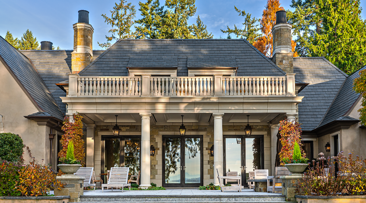 Classical luxury estate featuring custom-carved Lueders Limestone architectural details, including curved door surrounds, columns, and stone balustrades by Arris Stoneworks.