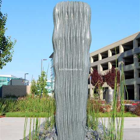 Large-scale commercial water feature at Moffett Towers, featuring custom-fabricated Sea Green Granite with precision water-flow edges. Artist: Cliff Garten.