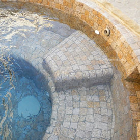 Sunk circular flooring feature in a luxury wellness spa utilizing precision-cut Antique Granite masonry units.