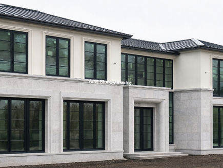 Modern residential exterior with smooth honed Harbor Grey Limestone cladding and precision structural stone elements.