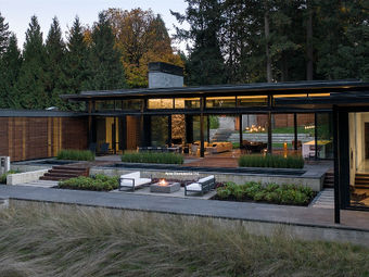 Custom-cut Obsidian Basalt patio pavers and integrated stone wall caps for a contemporary forest residence.