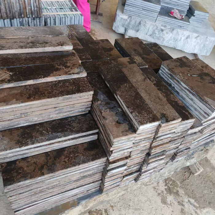 Production stack of Montipora Limestone wall cladding panels, highlighting the material's varied textural finishes and uniform calibration for easy installation