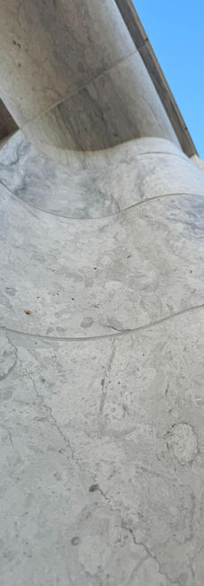 Custom limestone finishes. Massive architectural limestone block with a custom radiused curved profile on a modern building exterior.