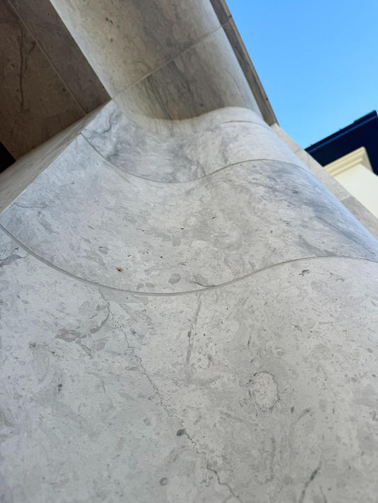 Radial-cut Harbor Grey limestone cladding showcasing seamless joint alignment on a curved architectural surface.
