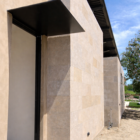 Minimalist exterior building surrounded by large-format Coffee Limestone wall cladding.