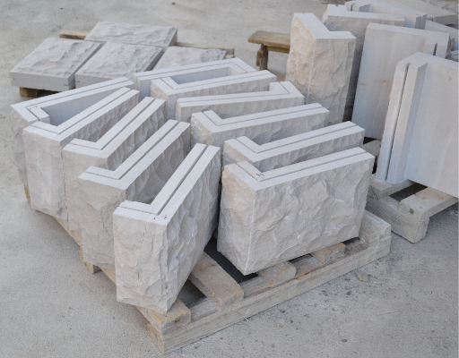 Custom L-shaped corner blocks machined from Dove Grey Limestone with a heavily textured, rustic split-face finish.