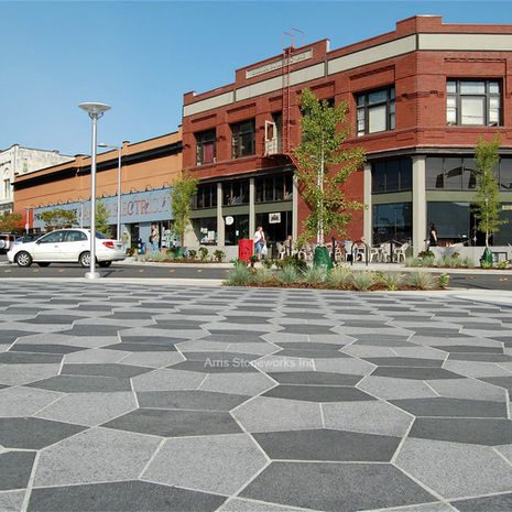 Ground-level view of the Bellingham Art Street corridor featuring custom stone paving and modern street furniture.