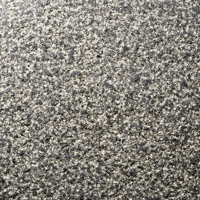 Lychee finish on Pepper Corn Granite providing a heavily pitted, high-traction surface that highlights the dense mineral structure for exterior hardscaping.