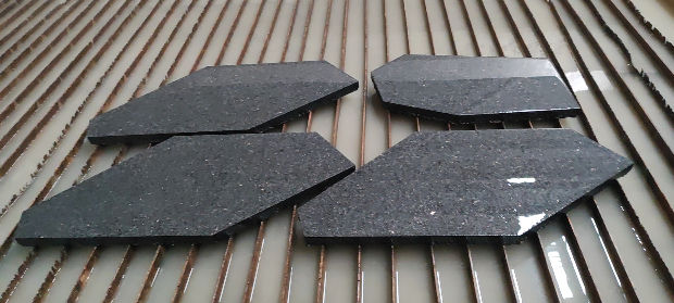 Large-format Black Galaxy Granite panels with custom trapezoidal cuts, highlighting advanced CNC fabrication for modern geometric facade systems.
