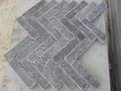 Interlocking herringbone pattern paving mockup utilizing honed and tumbled dark grey Mare Limestone brick pavers.