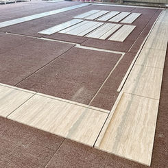 Large scale factory dry-lay layout of honed filled Argent Grigio Travertine panels for architectural color-blending verification.