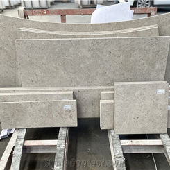 Looking closely at stacked, precision-cut curved Pewter Limestone blocks resting on a shipping pallet.