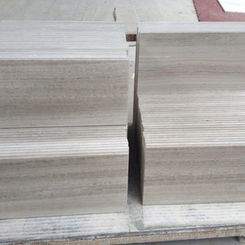 Precision-cut thick blocks of White Wood Vein Limestone stacked in the workshop, demonstrating the stone's dense structure and consistent 'timber' aesthetic.