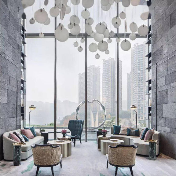 Large-scale commercial interior featuring Cinder Basalt stone walls, showcasing natural light and shadow play on vesicular basalt surfaces.