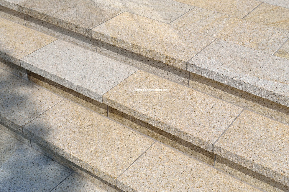 Modern outdoor staircase and patio featuring Sorrel Granite pavers and thick-tread stairs with a slip-resistant Lychee finish by Arris Stoneworks.