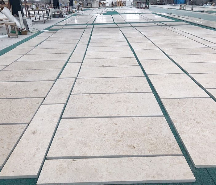 Production view of a Khaki Limestone walkway layout, showcasing the warm beige palette and precise parallel joint cutting for a custom project.