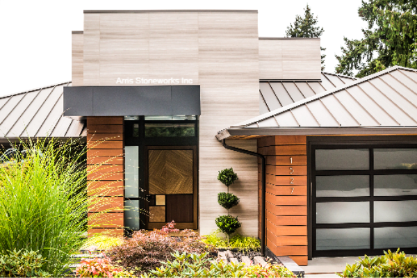 Exterior of the Kirkland Residence showing the contrast between light White Wood Vein Limestone and dark Montipora Limestone accents.