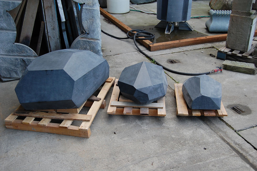 Sculptural Imperial Black Granite sitting stones with a smooth honed finish on all sides, designed as functional landscape art by Arris Stoneworks.