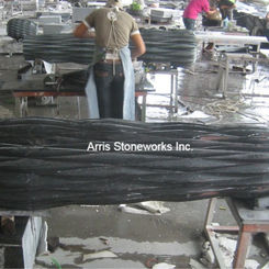 Production of a monolithic Imperial Black Granite 'Sitting Stone,' showcasing the material's dense, uniform black crystalline structure and the advanced structural fabrication required for functional art.