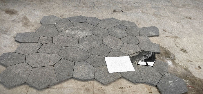Technical dry-lay of hexagonal Black Galaxy Granite pavers, demonstrating precision geometric cutting and uniform metallic flecking for custom landscape hardscaping.