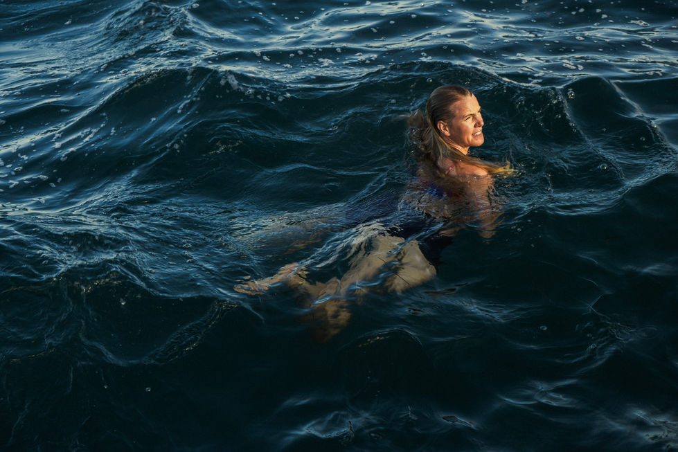 Person swimming in dark, wavy water.