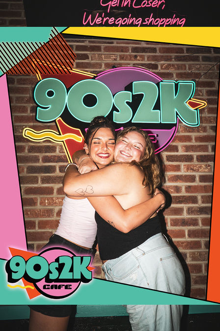 90s2k Cafe girls hugging in front of neon sign