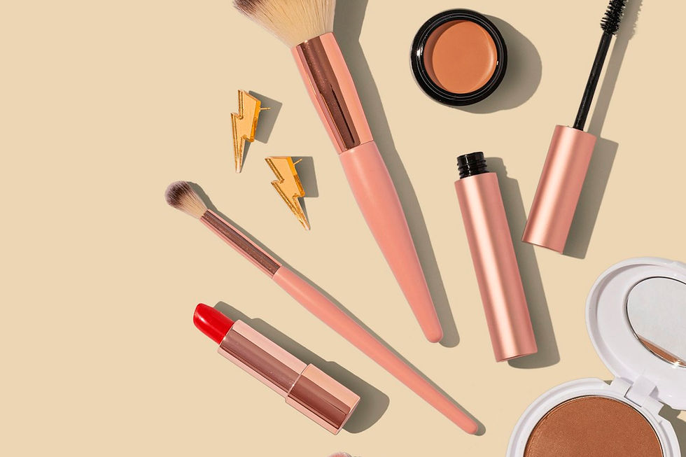 Clean beauty beginner makeup starter kit with lip gloss, mascara, tinted moisturizer, and setting spray on a white surface