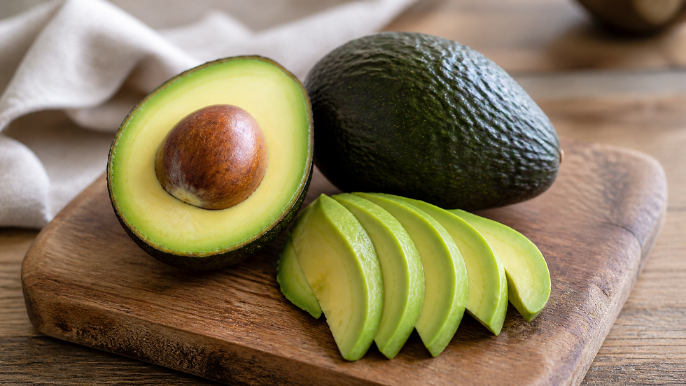 A ripe avocado cut in half with the seed intact, placed on a slightly worn wooden cutting board.