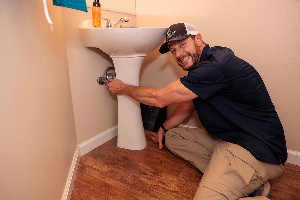 Plumber repairing a pedestal sink in a bathroom