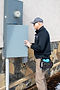 Technician inspecting an outdoor electrical panel.