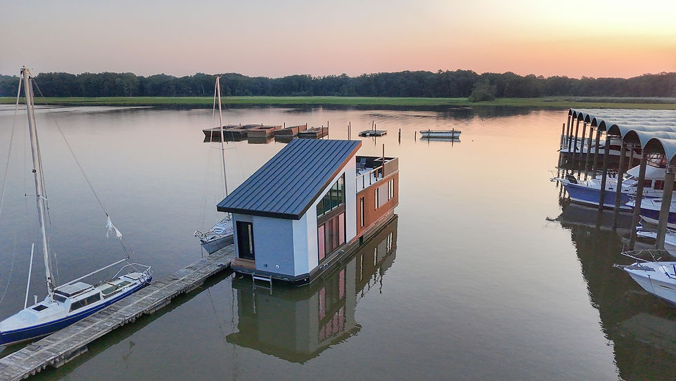 House boat and sailboat on calm lake at dusk