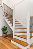 Modern curved wooden staircase with white banisters