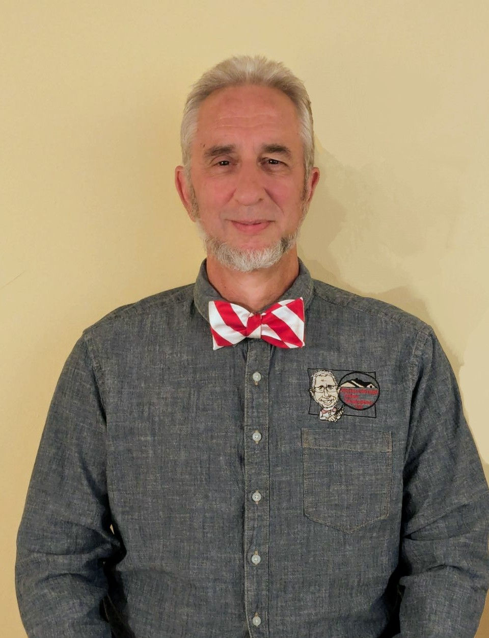 Portrait of a man wearing a grey shirt and red-striped bowtie