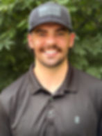 Smiling man wearing a grey baseball cap and polo shirt.