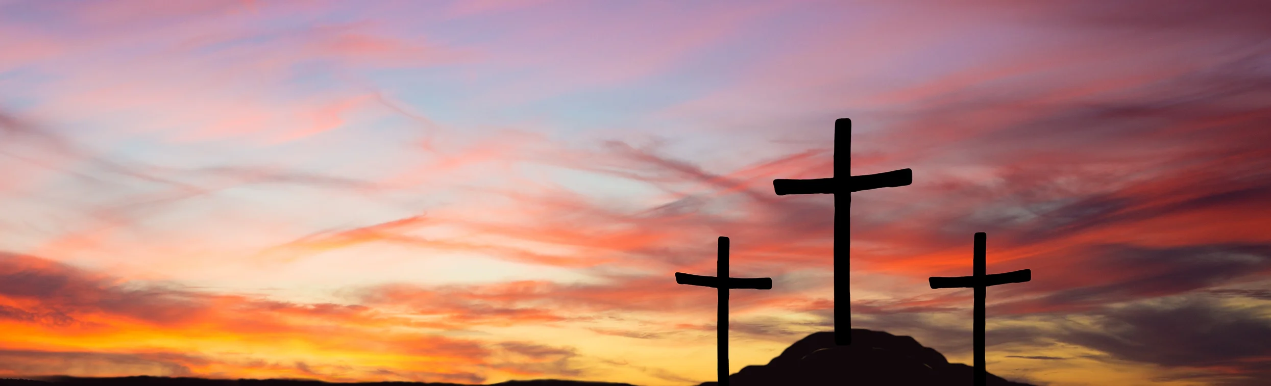 three crosses on a hill during sunrise